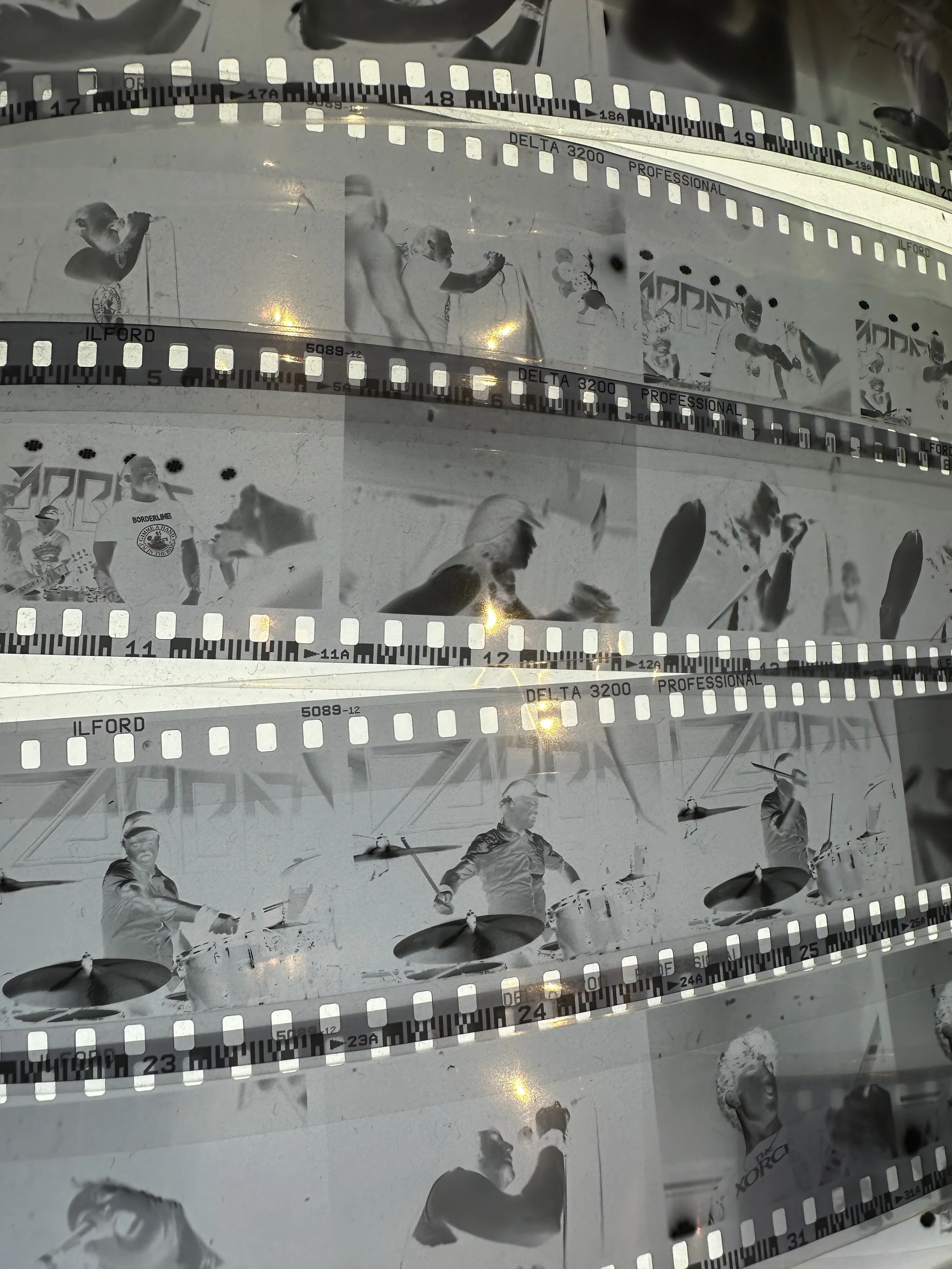 Strips of photographic film with pictures of people engaging in various activities, including playing drums and sports.